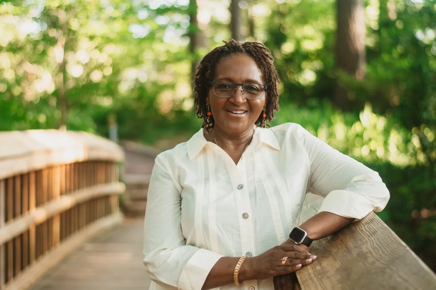 Josephine W. Hazeley, MSN, PMHNP-BC, smiling on a wooded footbridge